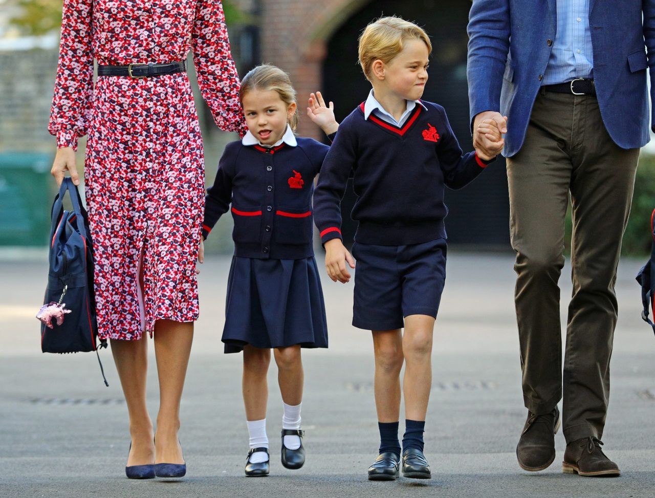 Princess Charlotte and Prince George in uniform at their school Thomas&#039;s Battersea. They are holding their parent&#039;s Prince William and Kate&#039;s hands.