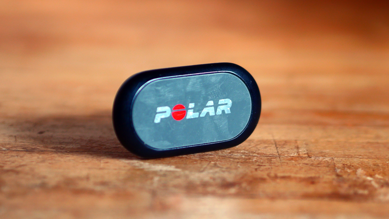 Polar H9 heart rate monitor pod on a wooden countr top
