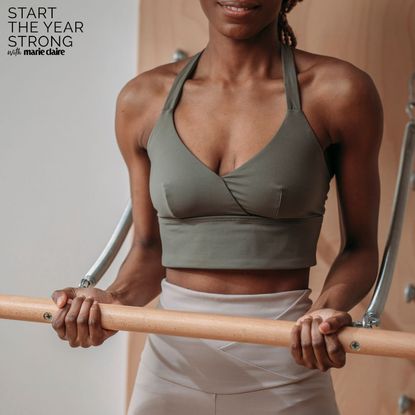 A woman working out in a studio with one of the best Pilates bars