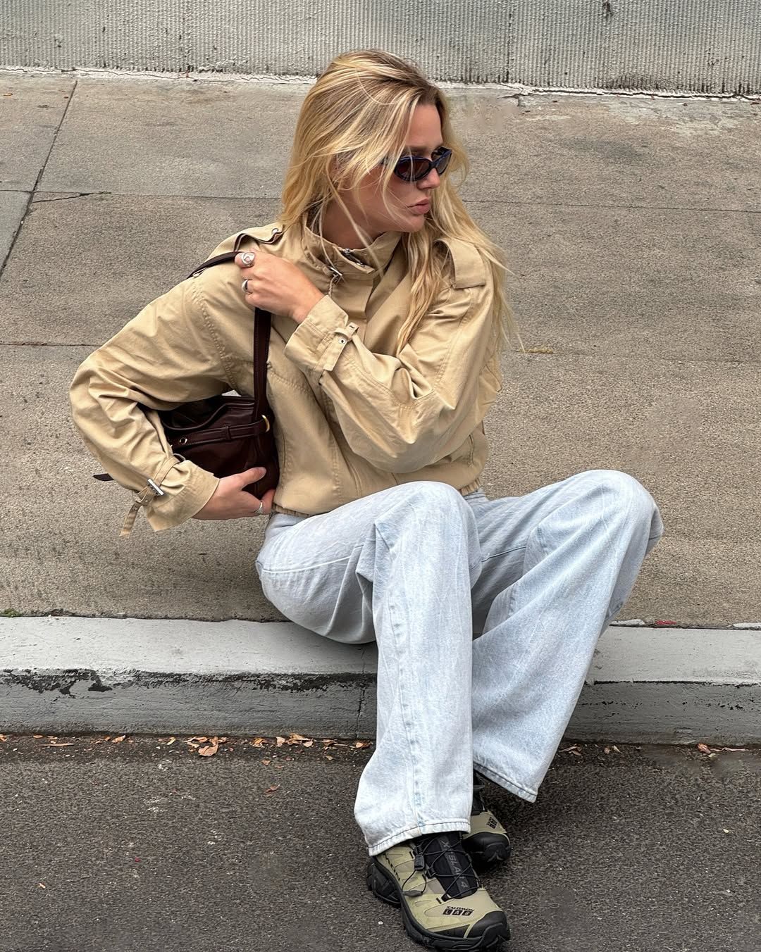 @meganadelaide wears a pair of faded jeans with a beige jacket and hiking trainers