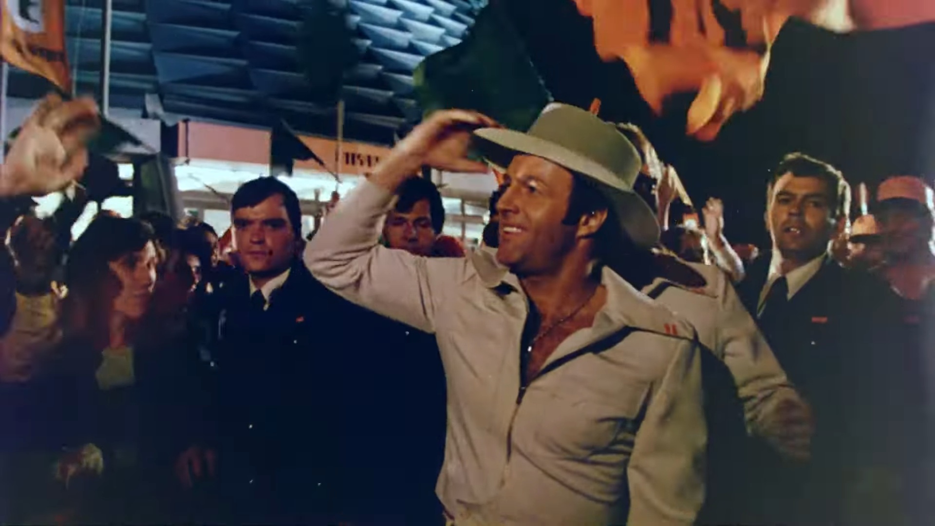 James Caan smiling and taking off his hat in Rollerball