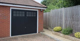 Brick house exterior with black painted garage door with glass panels to show how to make your house look expensive from the outside