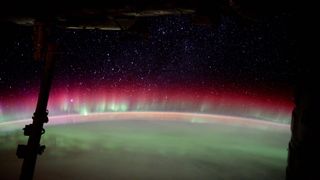 A photo of a rainbow aurora covering one side of the earth