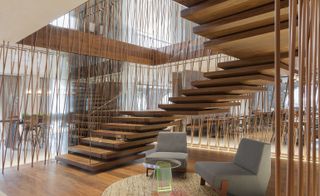 Large, wooden, floating staircase surrounded by criss-crossing wooden slats