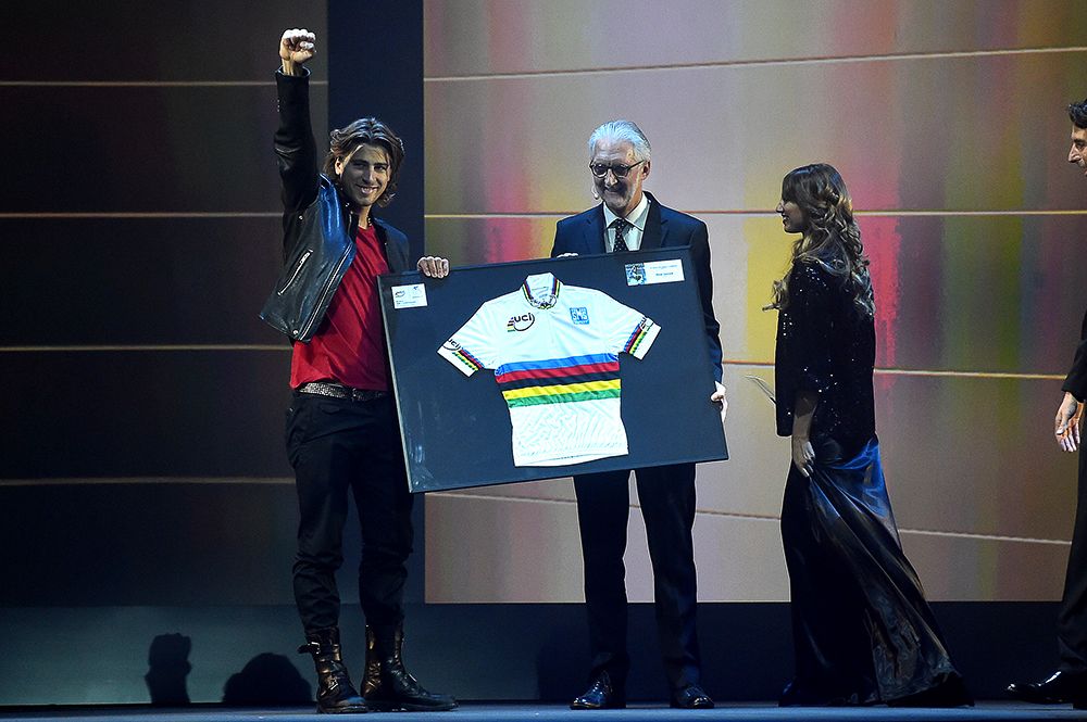 Peter Sagan salutes the crowd as he receives a framed rainbow jersey from Brian Cookson