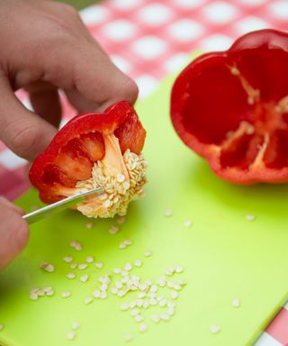 Removing seeds from a red bell pepper with a knife