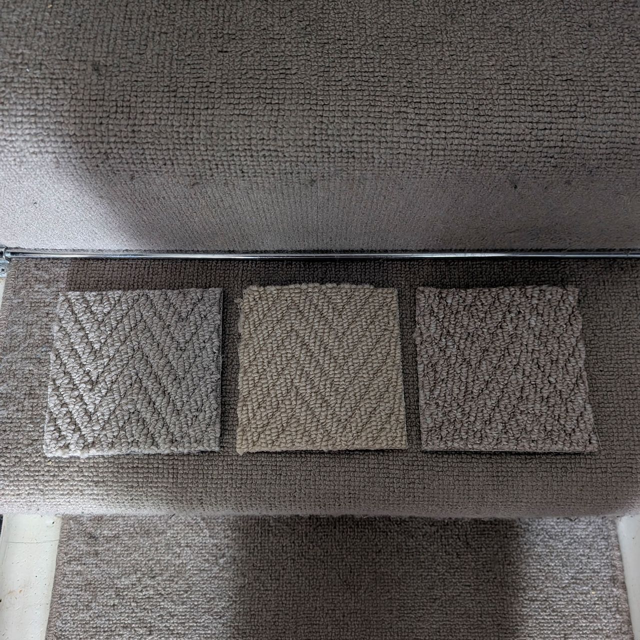 Three square neutral carpet samples sitting on grey carpet