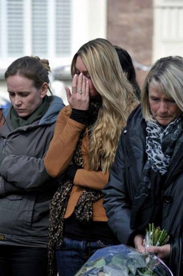 An-Sophie De Graeve wipes her eyes, accompanied by Wouter Weylandt's sister and mother