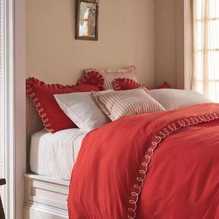 Red and white bedding with looped details on edge