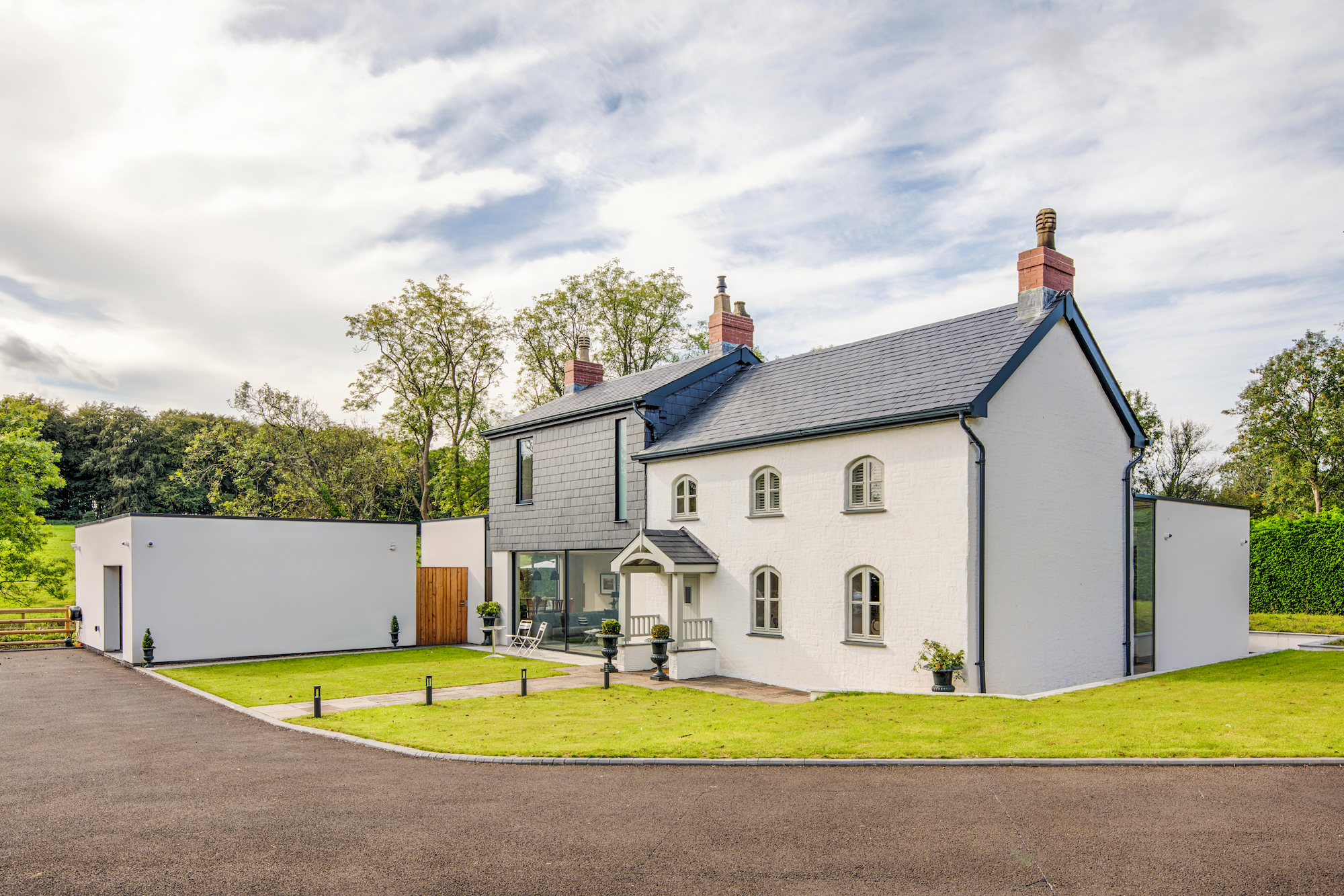 white rendered cottage with large two storage wrap around extension
