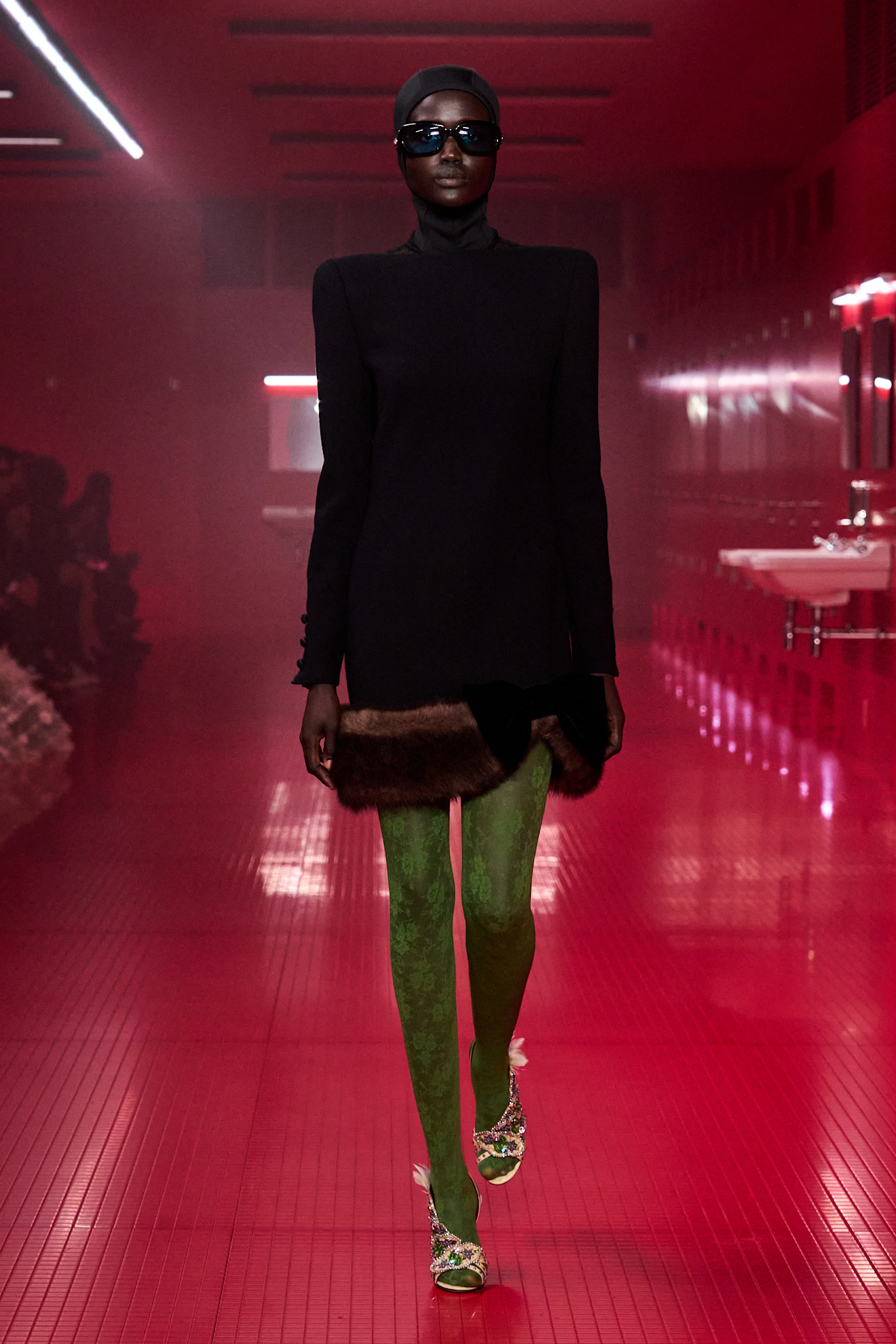 a Valentino Fall 2025 wearing a black velvet mini dress and green tights