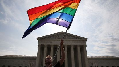 WASHINGTON, DC - JUNE 25: A gay marriage waves a flag in front of the Supreme Court Building June 25, 2015 in Washington, DC. The high court is expected rule in the next few days on whether s