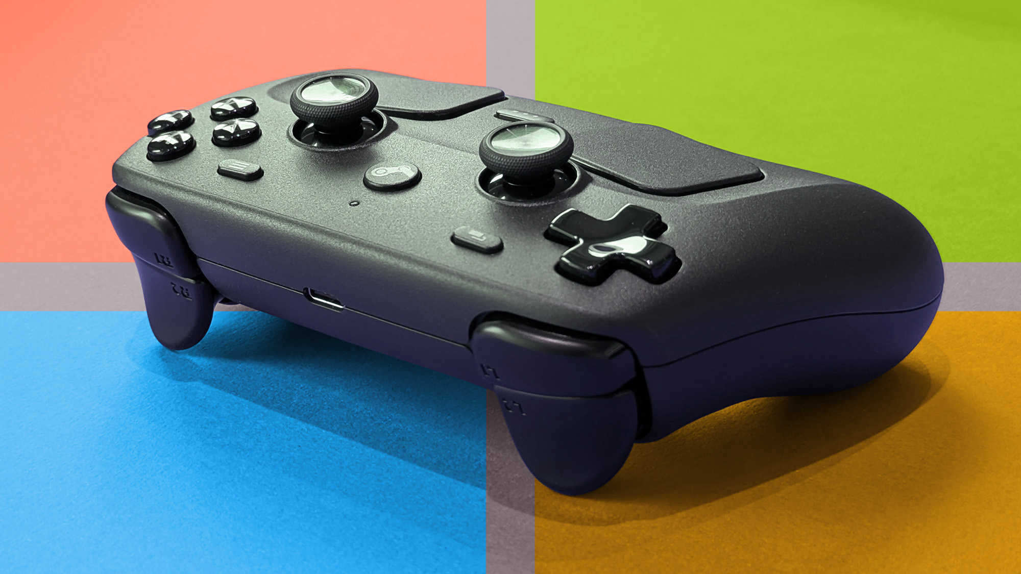 Steam Controller is positioned diagonally on a vibrant background showing colors of the Microsoft logo.