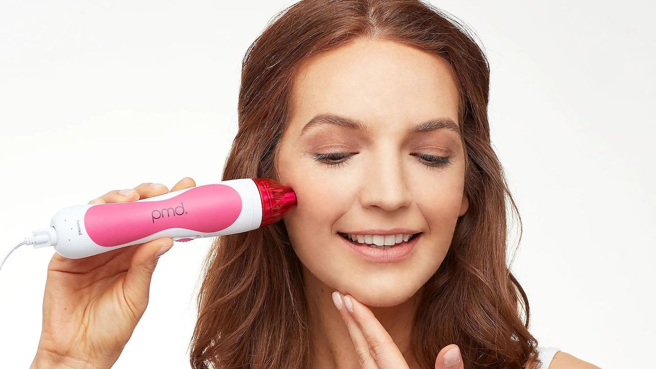 woman using the pink PMD Microderm device 