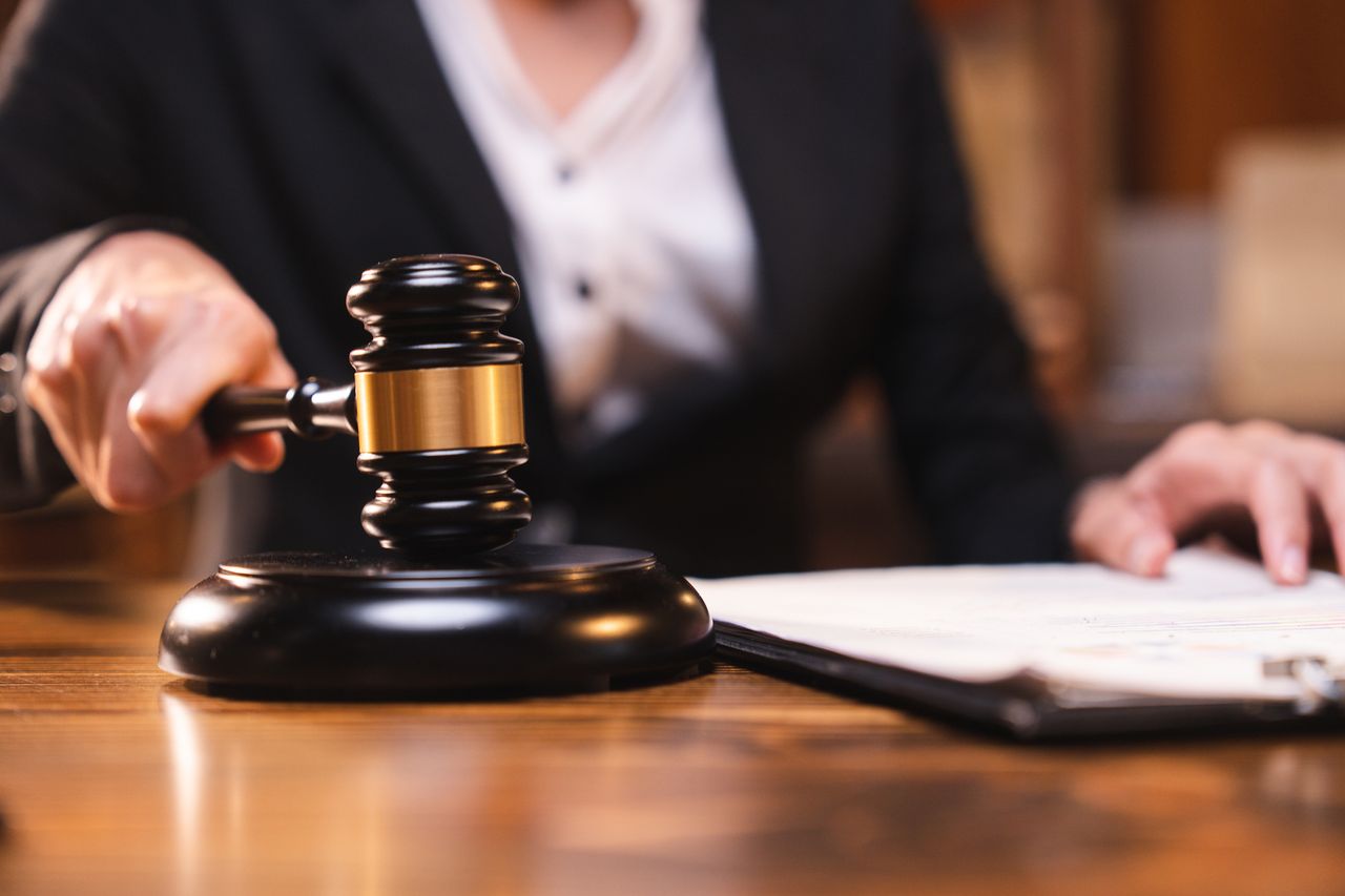 Judge gavel on the table with blurry books in the background