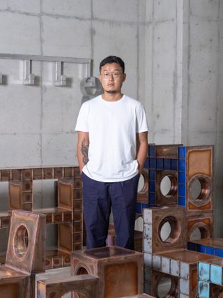 Kwangho Lee photographed in his Hanam studio, on the outskirts of Seoul in July 2022 with his enamelled copper pieces for Salon 94