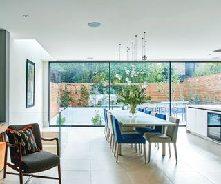 large open plan kitchen extension with island, dining table and chairs and glazed doors at end of room