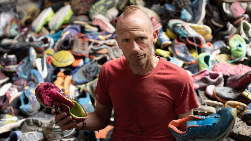 Damian Hall with a pile of discarded running shoes