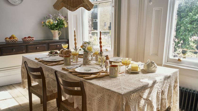 dining room with crochet tablecloth, wicker pendant light, table set, wooden shutters at sash window