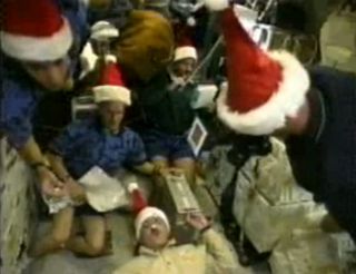 This still from a NASA video shows the only Christmas holiday mission by a space shuttle crew. The astronauts of NASA's STS-103 mission in December 1999 visited the Hubble Space Telescope for a repair flight and donned Santa hats to mark the Christmas holiday in space.