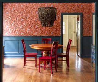 A deep toned dining room with wallpaper