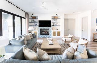 blue and cream living room with white walls, blue sofas, pale wood coffee table