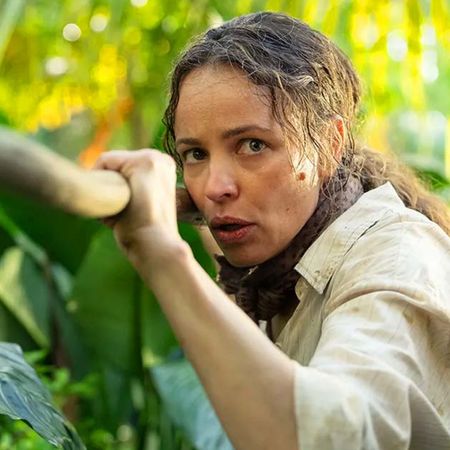 rachel mcadamas walks through a palm tree covered jungle holding a spear in a still from the 2026 survival thriller send help