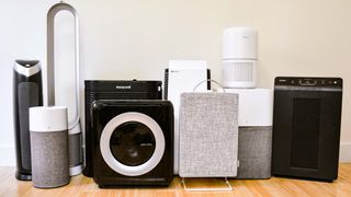 A line up of the air purifiers tested by Tom's Guide on a wooden floor against a white wall