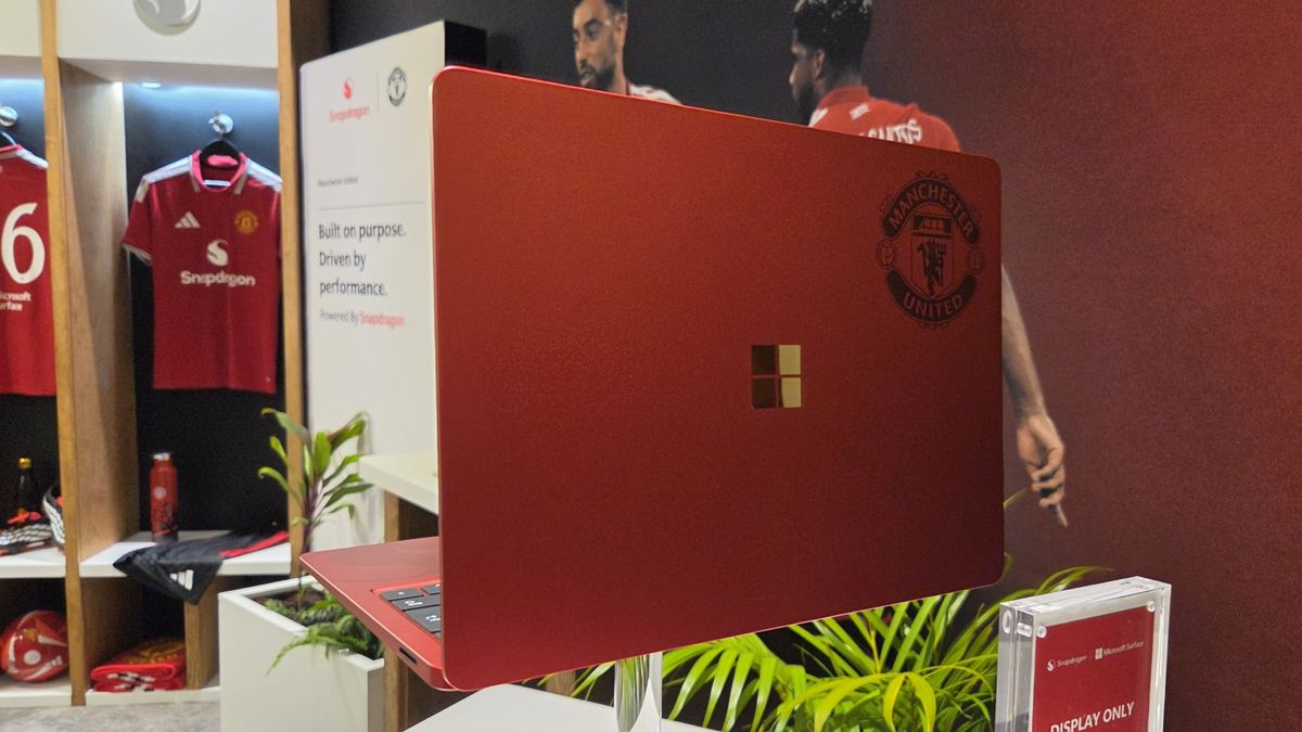 Microsoft Surface Laptop 13-inch 2nd Edition with Manchester United and Qualcomm Snapdragon branding on a red chassis, displayed with football imagery