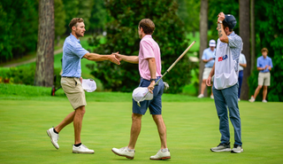 Bobby Massa and Evan Beck shake hands on the 18th green