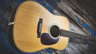A Martin D28 acoustic guitar with solid East Indian rosewood body with solid sitka spruce top, resting on a distressed wooden panel