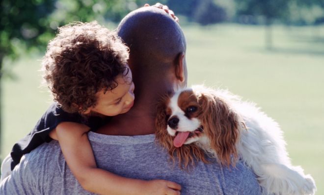 Man carrying child and dog