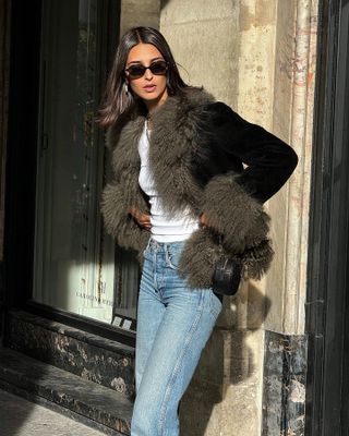 Salome Mory wearing faux-fur trimmed jacket, blue jeans and sunglasses