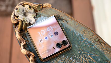 The Motorola Razr Plus 2025 on a fancy plate with its cover screen illuminated and unlocked