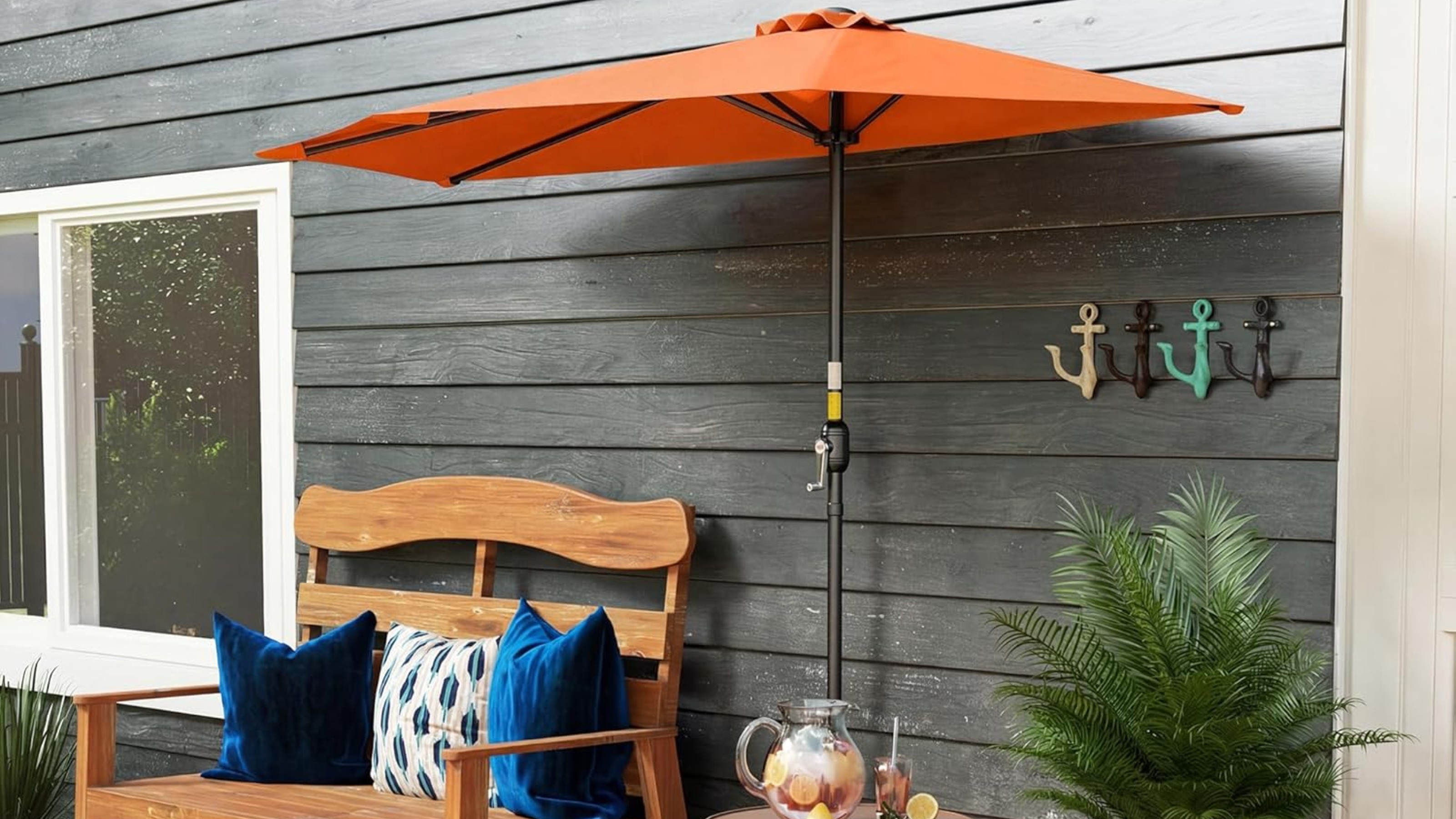 Outsunny orange half parasol on a porch next to a wooden bench