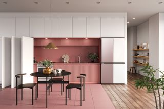 Two-tone Samsung ‘Bespoke’ fridge in a pink and white kitchen with dark round dining table, chairs, wooden shelving and a plant