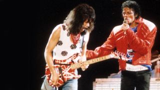 Eddie Van Halen plays guitar on stage with Randy Jackson, Michael Jackson and Jermaine Jackson during the Victory Tour