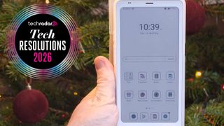 A hand holding the Boox Palam 2 Pro in front of a Christmas tree