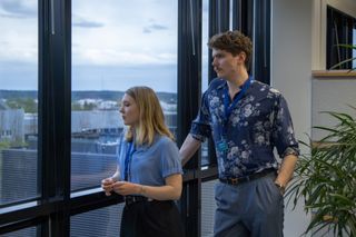 An image from Mobile 101 showing Katarina (Satu Tuuli Karhu) and Aki (Emil Kihlström) inside an office looking out of the window