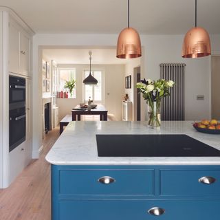 Open plan kitchen with navy island and gunmetal cup handles