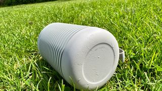 Beosound Explore Bluetooth speaker on its side in the grass