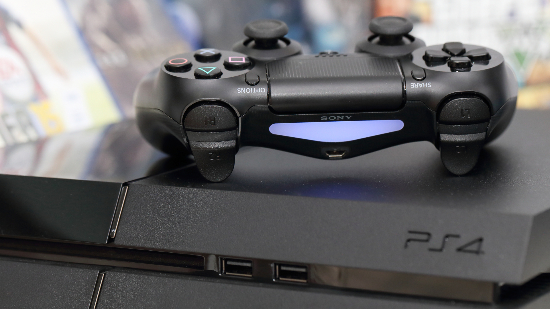 DualShock 4 controller sat on top of a PS4 console