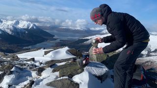 Coach Brian Sharp makes coffee for his clients atop the Pap of Glencoe