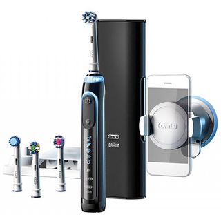 Black Braun Oral B electric toothbrush with multiple heads and smartphone