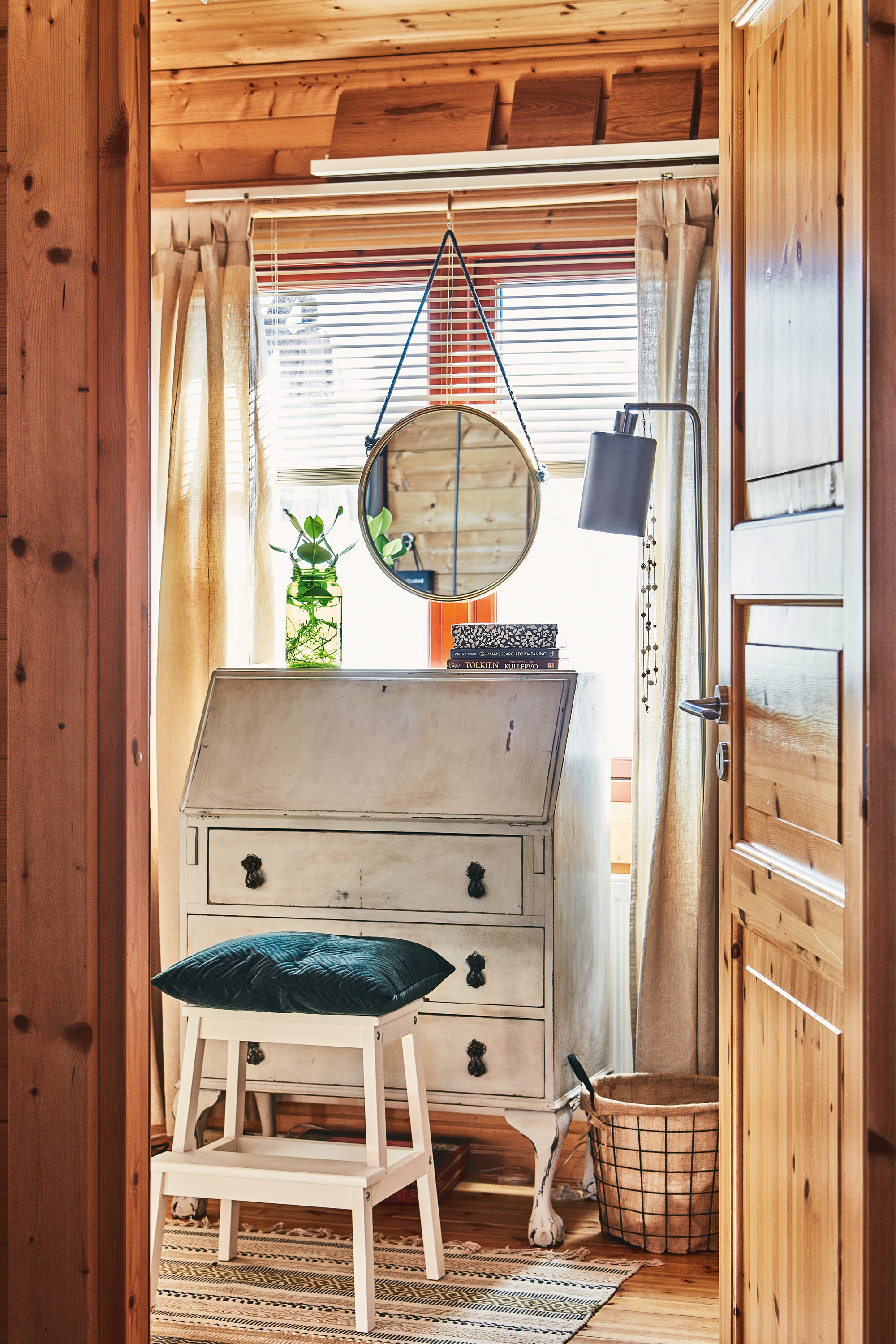 An open door reveals Pia's library/office, featuring an antique bureau and stool