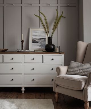 white dresser, armchair and black vase