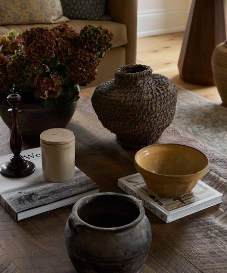 a collection of vases and bowls on a wood table
