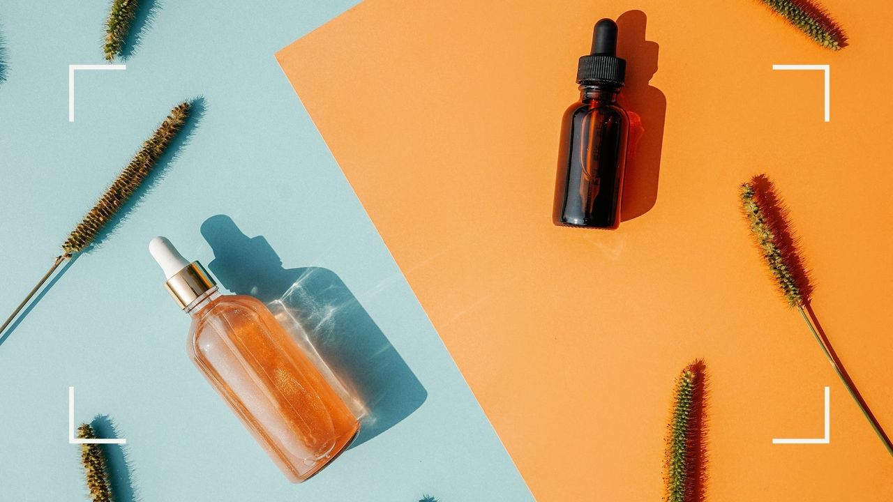 Retinol vs Vitamin C serums, both bottles pictured on a blue backdrop