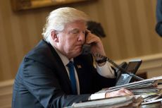 President Donald Trump speaks on the phone with Russian President Vladimir Putin in the Oval Office of the White House on Jan. 28, 2017.