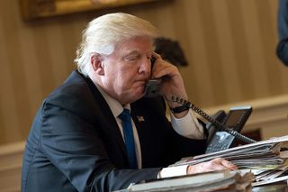 President Donald Trump speaks on the phone with Russian President Vladimir Putin in the Oval Office of the White House on Jan. 28, 2017.